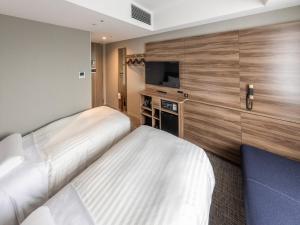 a hotel room with two beds and a flat screen tv at Far East Village Hotel Tokyo Ariake in Tokyo