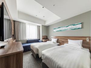 a hotel room with two beds and a couch at Far East Village Hotel Tokyo Ariake in Tokyo