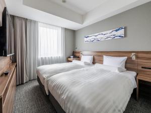 a hotel room with a large bed and a television at Far East Village Hotel Tokyo Ariake in Tokyo