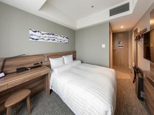 a bedroom with a bed and a desk and a television at Far East Village Hotel Tokyo Ariake in Tokyo
