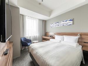 a hotel room with a bed and a television at Far East Village Hotel Tokyo Ariake in Tokyo