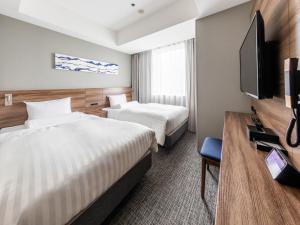a hotel room with two beds and a flat screen tv at Far East Village Hotel Tokyo Ariake in Tokyo