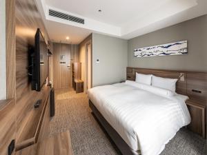 a bedroom with a large white bed and a television at Far East Village Hotel Tokyo Ariake in Tokyo