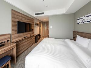 a hotel room with a large bed and a flat screen tv at Far East Village Hotel Tokyo Ariake in Tokyo