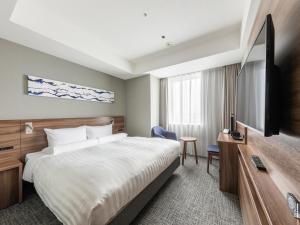 a hotel room with a bed and a flat screen tv at Far East Village Hotel Tokyo Ariake in Tokyo