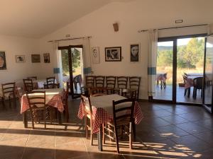 a dining room with tables and chairs and a patio at Agriturismo Turudhis in Tortolì