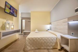 1 dormitorio con 1 cama y TV en la pared en Hotel Salento Mirfran, en Torre San Giovanni