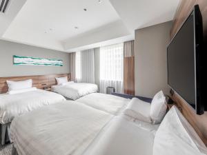 a hotel room with two beds and a flat screen tv at Far East Village Hotel Tokyo Ariake in Tokyo