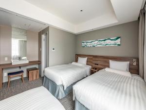 a hotel room with two beds and a desk at Far East Village Hotel Tokyo Ariake in Tokyo