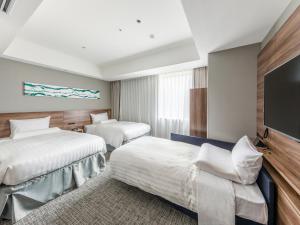 a hotel room with two beds and a flat screen tv at Far East Village Hotel Tokyo Ariake in Tokyo