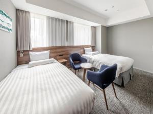 a hotel room with two beds and two chairs at Far East Village Hotel Tokyo Ariake in Tokyo