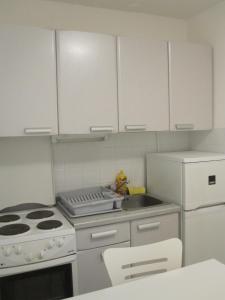 a kitchen with white cabinets and a stove and a sink at Zaglav Iva in Martinšćica