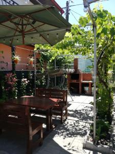 a picnic table and benches under an umbrella at Casa Remus in Sulina