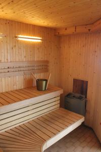 a wooden sauna with a bucket and a stove at Wanbo Herrgård in Nedre Vanbo