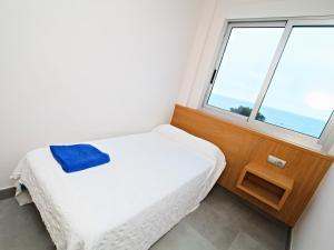 a small bedroom with a bed and a window at Apartamentos Bravosol VyB in Denia