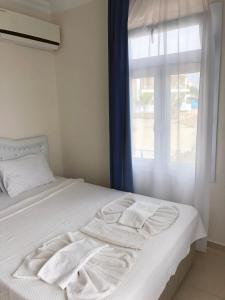 a bedroom with a white bed with a window at Cunda La Vie in Balıkesir