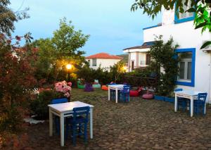 a yard with tables and chairs in front of a building at Cunda La Vie in Balıkesir