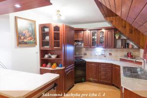 a kitchen with wooden cabinets and white counter tops at Ubytovanie Adina Poltár in Poltár