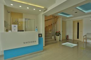 a lobby with a reception desk and a staircase at Alarzo Rooms in Paralia Katerinis