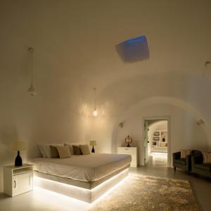a white bedroom with a bed and a couch at White Dream Suites in Fira