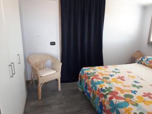 una camera con letto e sedia di Casa vacanza Mansarda Sanleonina a Agrigento