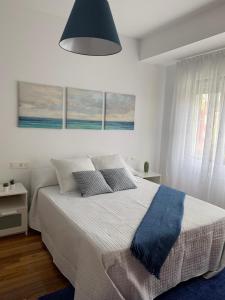 a bedroom with a large bed with a blue blanket at O rincón da Camposa in Muxia