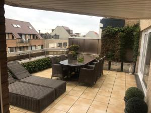 patio ze stołem i krzesłami na balkonie w obiekcie Residentie Zeebries, luxe en ruim appartement met zijzicht op zee w mieście Knokke-Heist