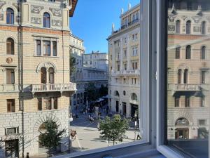 una finestra con vista su una strada della città di Trieste Center Rooms & Apartments a Trieste