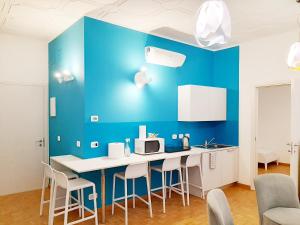 una cucina con parete blu e bancone con sgabelli di Trieste Center Rooms & Apartments a Trieste