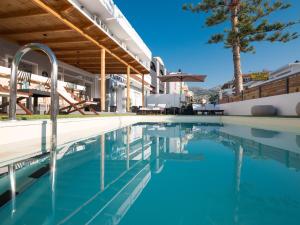 a swimming pool in front of a house at Pasiphae Hotel in Malia