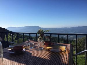 una mesa con platos y vasos en la parte superior de un balcón en CAN LLOBET Espai Rural Slow, en Fogars de Montclus