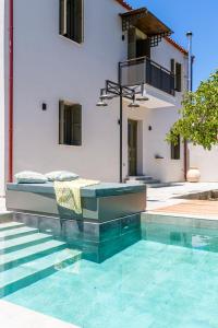 a house with a bed and a swimming pool at Villa Skyphos in Ammoudari