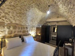 a room with a table and a stone wall at AĞAOĞLU HAN OTEL in Mardin