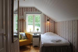 a small bedroom with a bed and a yellow chair at Wanbo Herrgård in Nedre Vanbo +89 photos