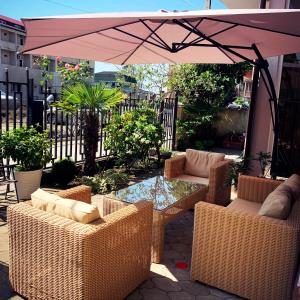 une terrasse avec une table, des chaises et un parasol dans l'établissement Hotel Crown, à Ureki