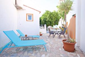 un patio con sillas azules y una mesa en La Villa Suite Málaga, en Málaga