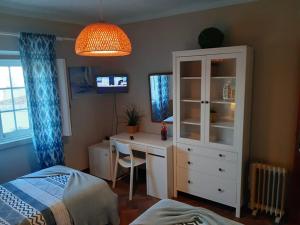 a bedroom with a desk and a cabinet and a bed at Casa Mestre in Vila do Bispo