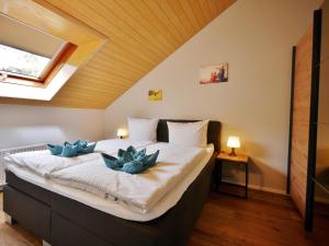 Un dormitorio con una cama con dos flores azules. en Fewo Blumes Bergfrieden mit MeineCardPlus, en Willingen