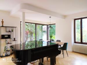 a living room with a piano and a dining table at VILLA SERANDITE maison de famille in Annecy +24 photos