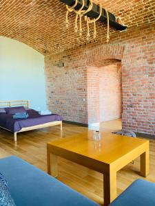 a room with a wooden table and a brick wall at Apartament Stara Przędzalnia in Żyrardów