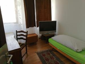 a bedroom with a bed and a tv and a chair at Gasthaus Zur Rose in Malsch