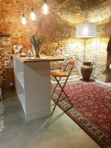 a kitchen with a counter and a chair on a rug at L' Atelier Tuscany in Peccioli
