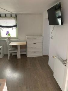 a small room with a desk and a table and a window at Ferienwohnung Hoppe in Bad Münder am Deister