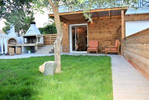 a house with a patio with two chairs and a grill at The Flintstones House in Limenaria
