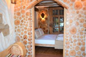 a bedroom with a bed in a stone wall at The Flintstones House in Limenaria