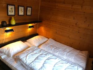 a bed in a room with a wooden wall at Sørlia hytte in Hafjell