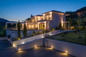 una casa grande con luces en una entrada de noche en Villa Elegance en Sinj