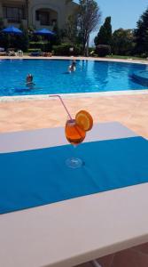 a drink sitting on a bench next to a swimming pool at Villa Romana in Topola
