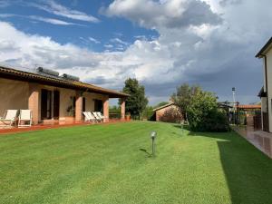 een tuin met een groot gazon met een huis bij Agriturismo Beveraggio Appartamenti in Marina di Grosseto