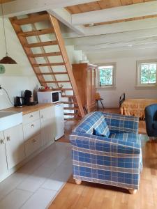 ein Wohnzimmer mit einem Sofa und einer Küche in der Unterkunft Bed&Breakfast Oudeschans in Oudeschans